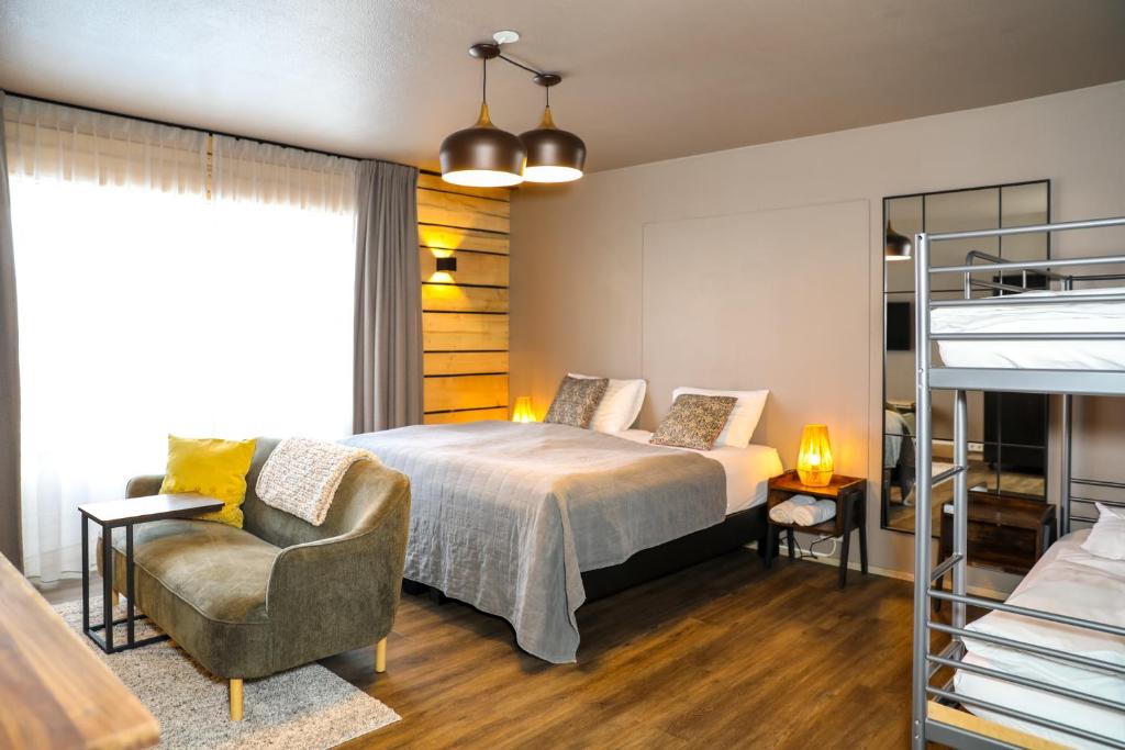 een slaapkamer met een bed, een bank en een stoel bij Akureyri Hostel in Akureyri