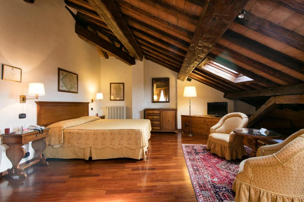 a bedroom with a bed and a table and chairs at Albergo Delle Notarie in Reggio Emilia