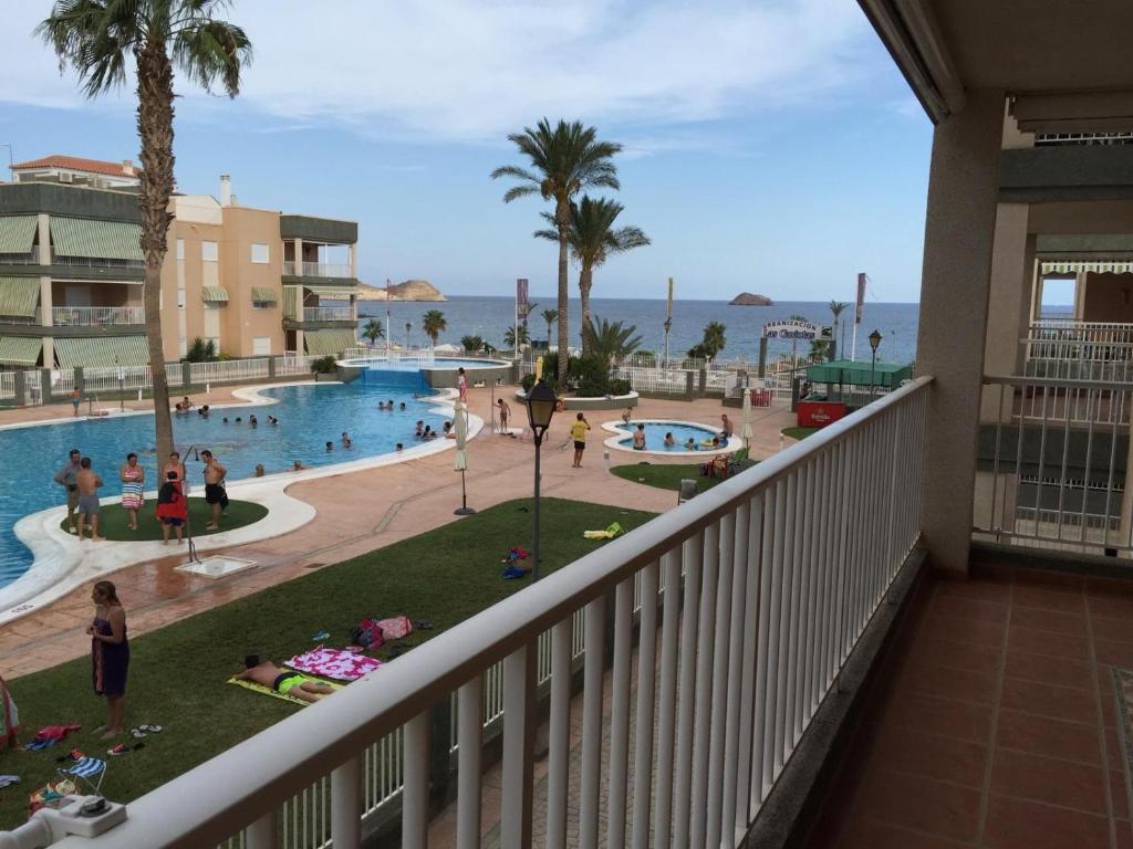 einen Blick auf den Pool vom Balkon eines Resorts in der Unterkunft Las Gaviotas in San Juan de los Terreros