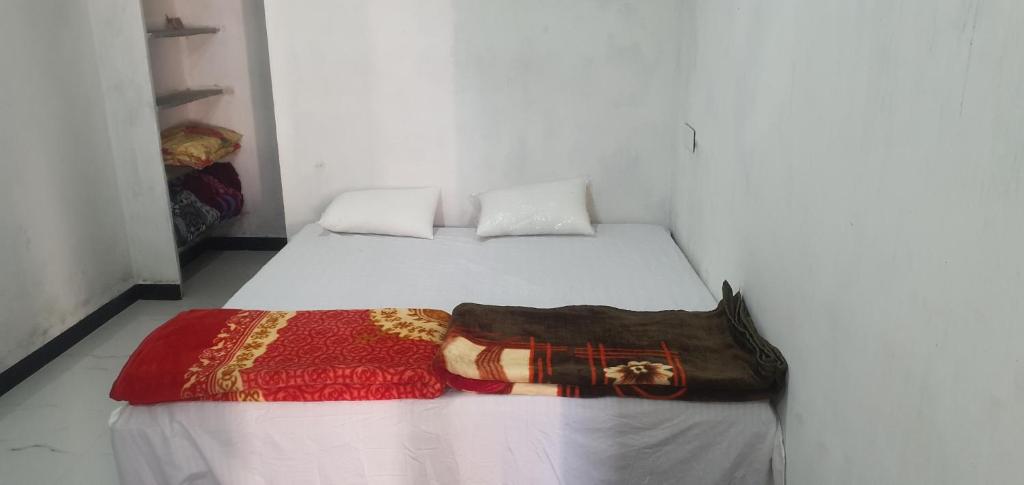um quarto branco com uma cama com um saco em City yatra em Ujaim