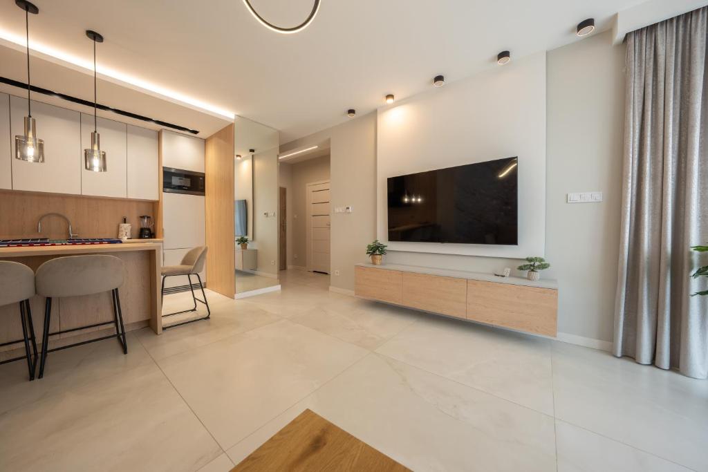 a large living room with a large television on a wall at Apartament z wielkim tarasem Morska 2 Rewal 50m do morza in Rewal