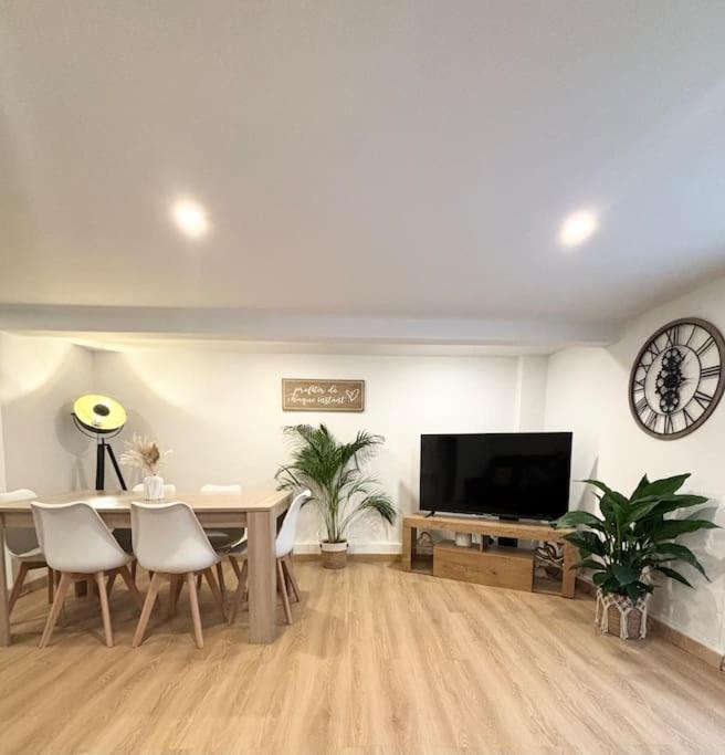 un salon avec une table à manger et une télévision dans l'établissement Maison chaleureuse proche Paris, à Châtillon