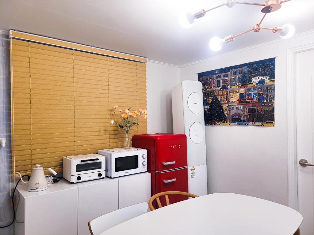 a kitchen with a red refrigerator and a microwave at Liebe House in Seoul