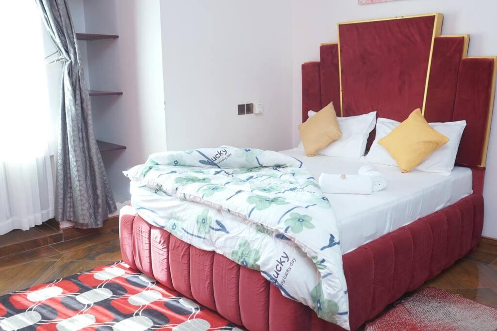 a bedroom with a bed with a red headboard at Shimbo Homes in Kutani