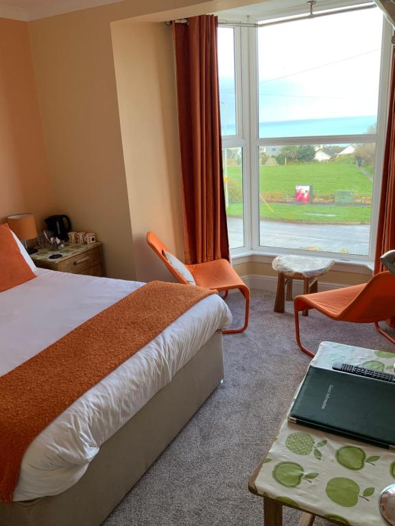 a hotel room with a bed and a large window at Green Apple Bed and Breakfast in Carbis Bay
