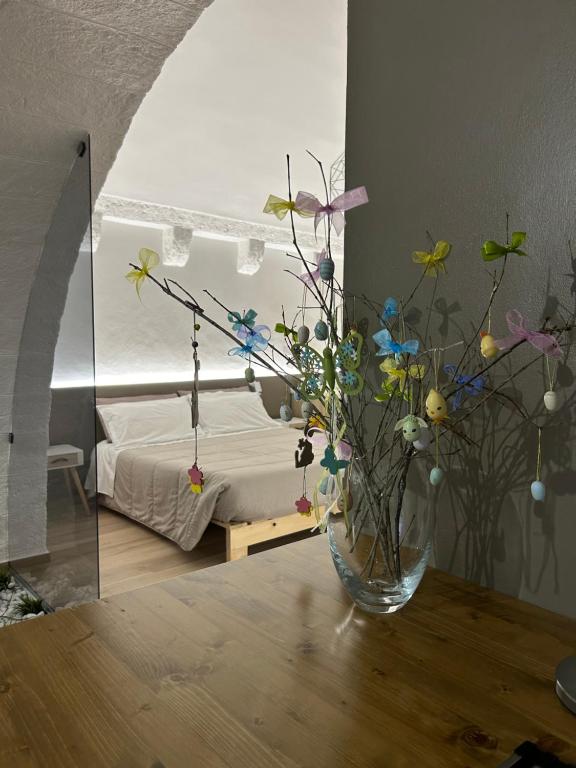 un vase de fleurs sur une table dans une chambre dans l'établissement Archome Luxury Apartment, à Brindisi