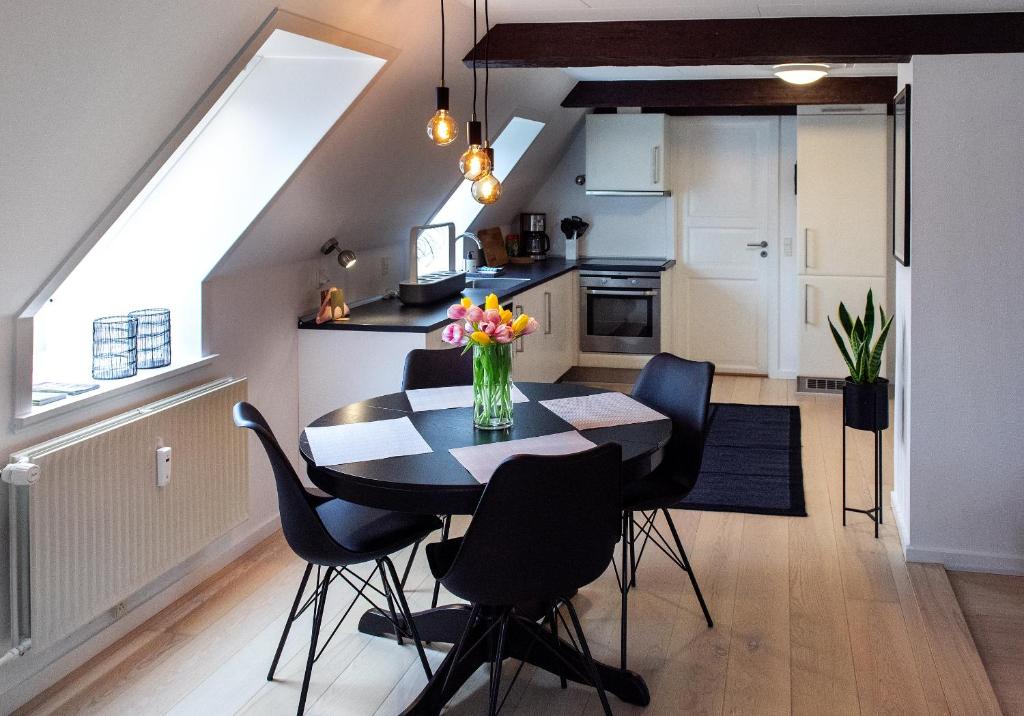 a kitchen and dining room with a table and chairs at Lejlighed med et eller to separate soveværelser in Ribe