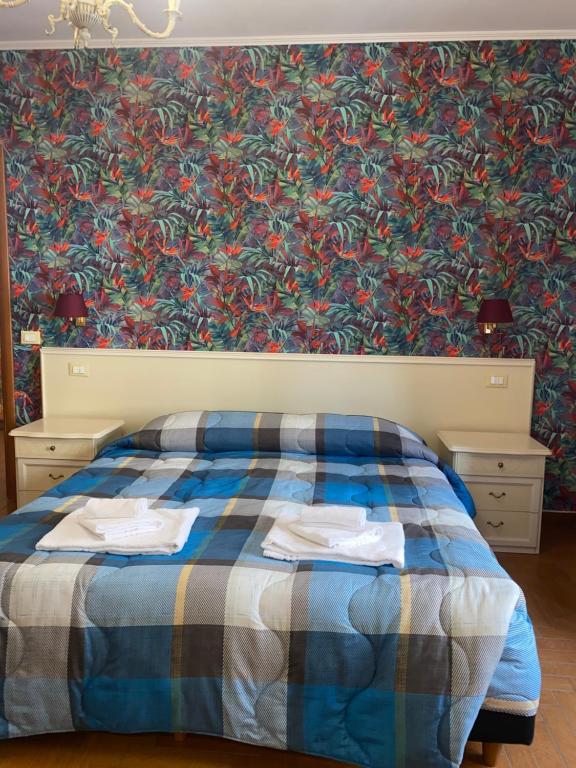 a bedroom with a blue bed with a floral wallpaper at Residenza in Rome