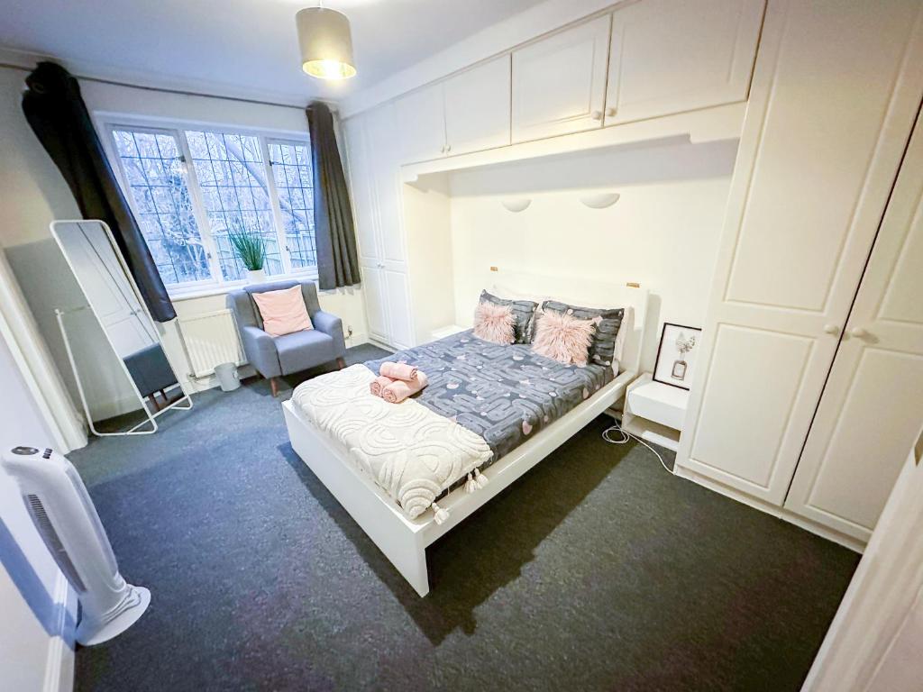 a bedroom with a bed with a doll on it at Cosy Apartments Near Hampstead Heath With Free On-Site Parking & Private Gardens, Golders Green in London