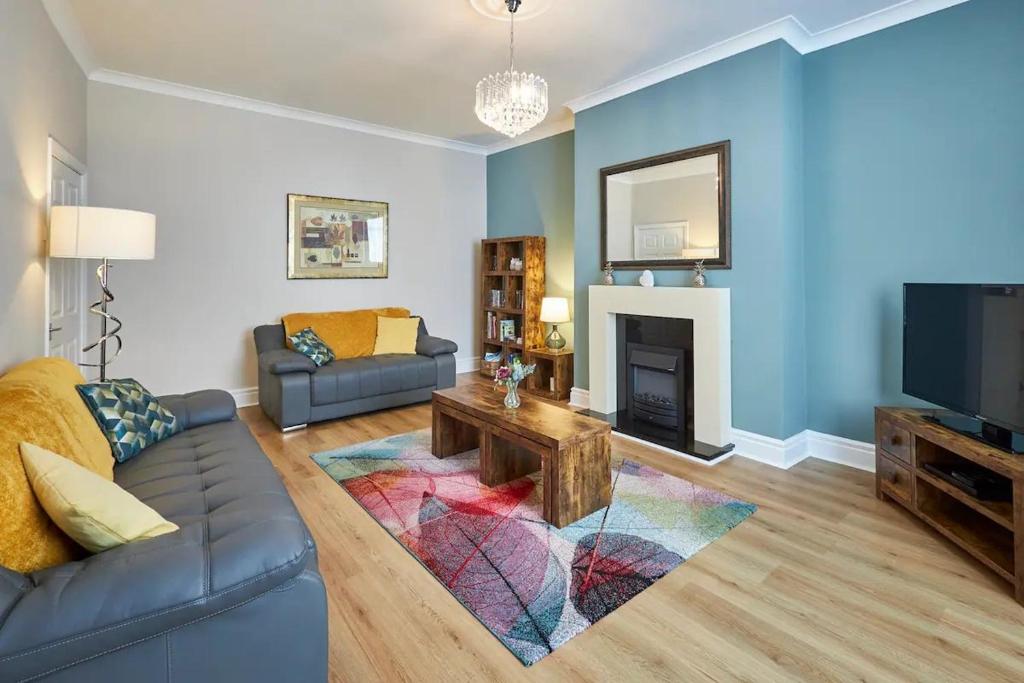 a living room with a couch and a tv at Pass the Keys Modern home in a seaside town in Seaham