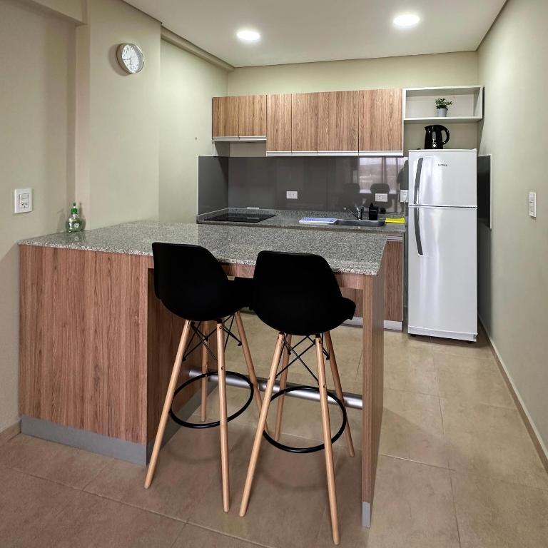 福爾摩沙的住宿－Costado Norte，厨房配有冰箱的柜台,设有两个黑色凳子