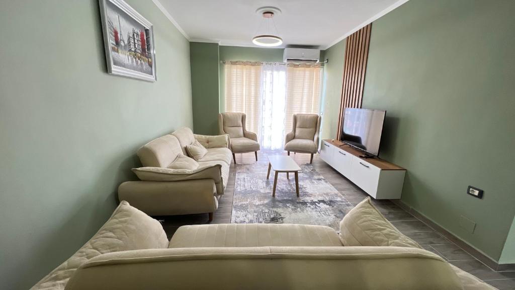 a living room with a couch and chairs and a television at Eden’s Apartament in Pogradec