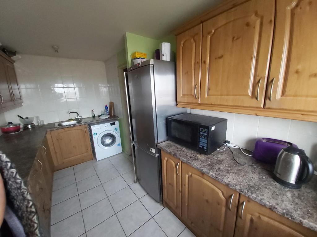 a kitchen with a refrigerator and a microwave at Essex Riverside in Grays Thurrock