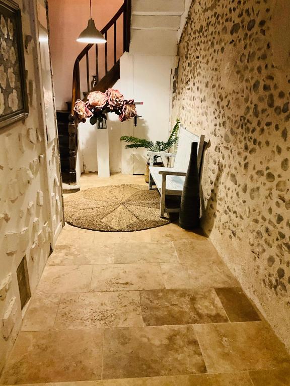 a hallway with a chair and a vase of flowers at No 25 superbe apartment plein centre calme ,Netflix in Mirepoix