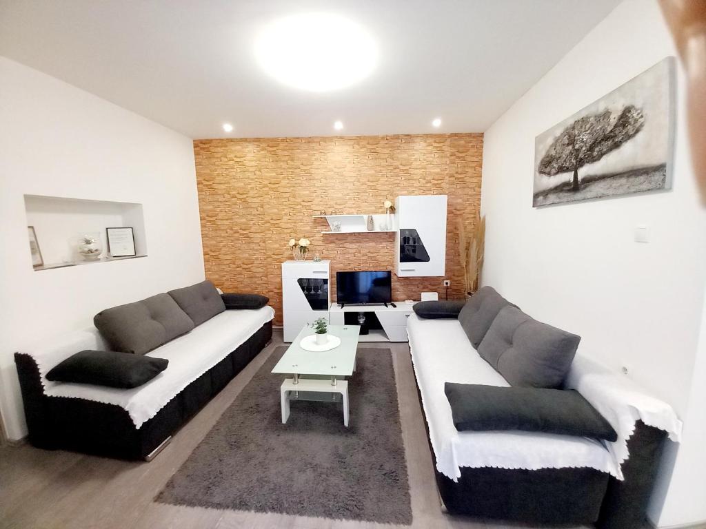 a living room with two couches and a table at Apartment Centar in Slavonski Brod