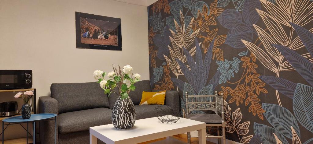 ein Wohnzimmer mit einem Sofa und einer Vase aus Blumen in der Unterkunft House - Sunlit haven with outdoor terrace and garage in Gentilly