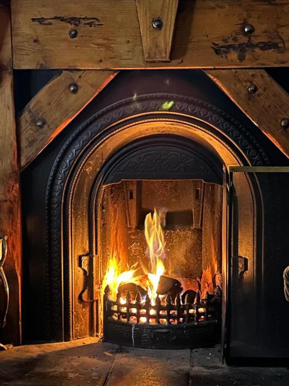 a fireplace with a fire in it at Cosy cottage with sea & mountain views Carnlough in Carnlough