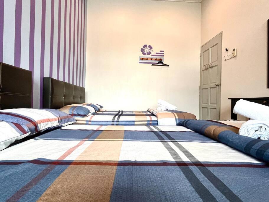 1 Schlafzimmer mit 2 Betten und einem Teppich auf dem Boden in der Unterkunft Seaside Bliss: Luxurious 5-Bedroom Retreat in Malakka