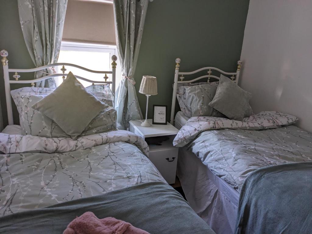 - 2 lits installés l'un à côté de l'autre dans une chambre dans l'établissement Cosy cottage Atlantic way, à Carnlough