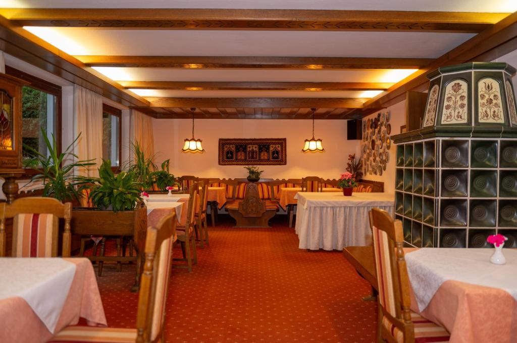 a dining room with tables and chairs and a room with tablesktop at Pension & Apartments Ertl in Seeboden