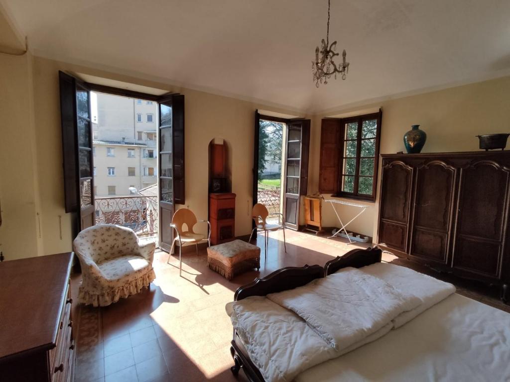 Casa Valduggia في Valduggia: غرفة نوم بسرير كبير في غرفة بها نوافذ