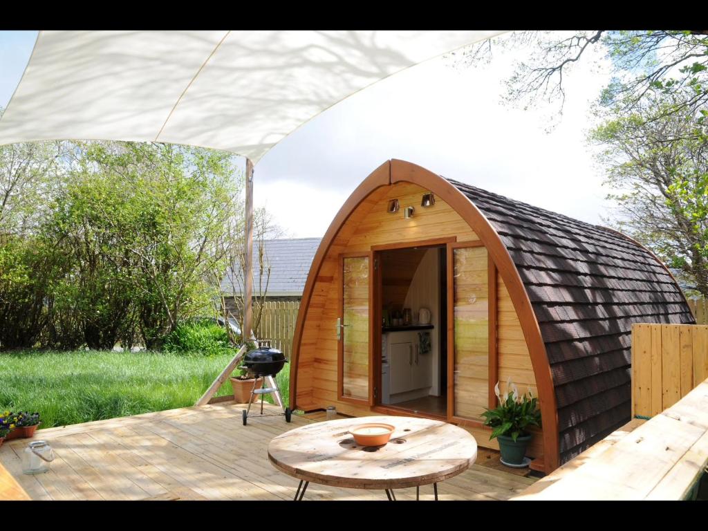 una piccola iguana in legno con un tavolo su una terrazza di South Kerry Glamping a Cahersiveen