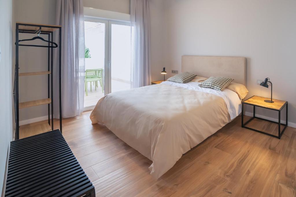 una camera con un grande letto e un pavimento in legno di Patios de Almería a Almería