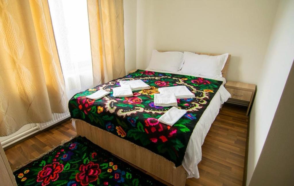 a bedroom with a bed with a flowered blanket at Casa Vădeanu in Sighetu Marmaţiei