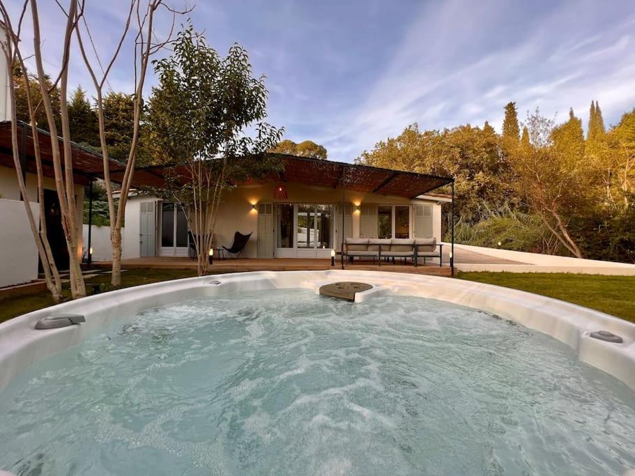 uma grande piscina de água em frente a uma casa em Cottage chaleureux avec jacuzzi en pleine nature em Grasse