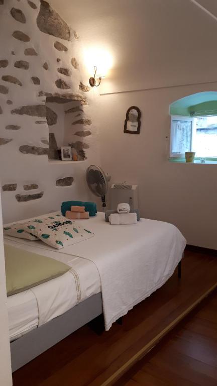 ein Schlafzimmer mit einem Bett mit einer weißen Decke in der Unterkunft CASA ATENA centro storico in Sanremo