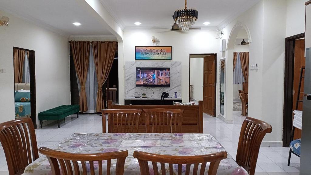 una sala da pranzo con tavolo e TV di Rinting Corner Islamic Homestay, Pasir Gudang a Masai