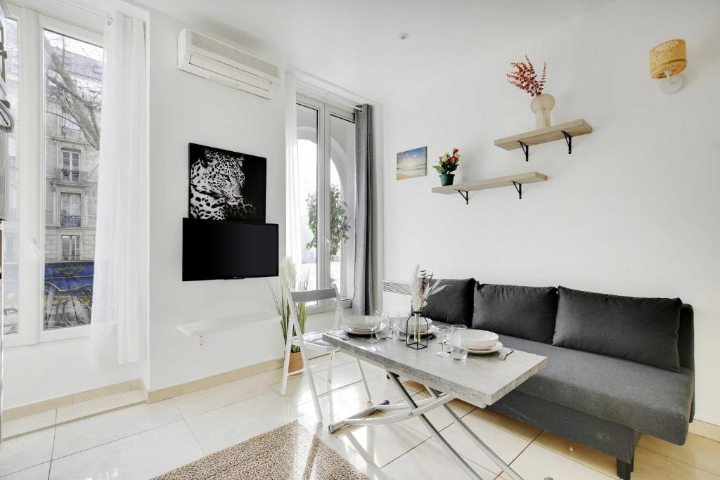 un salon avec un canapé et une table dans l'établissement Cozy apartment - 1BR-3P - Gare du Nord, à Paris