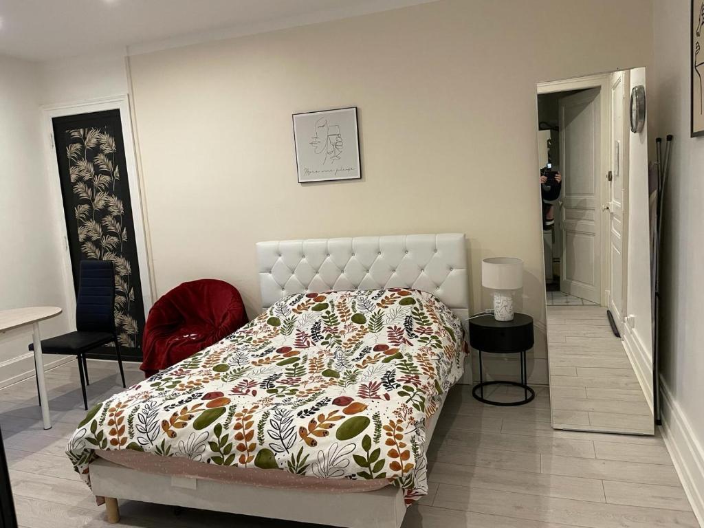 1 dormitorio con 1 cama y 1 silla roja en Studio meublé et lumineux 20m2 en Vittel