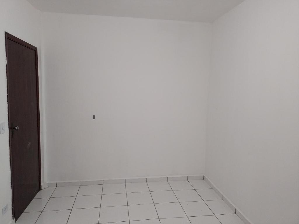 Habitación vacía con puerta y suelo de baldosa blanca en Casa para Lollapalooza, en São Paulo