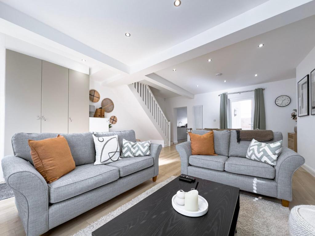 Sala de estar con 2 sofás y mesa en Salters Cottage - Stunning Modernised 3 BR Home Just Steps From the Beach, en Budleigh Salterton