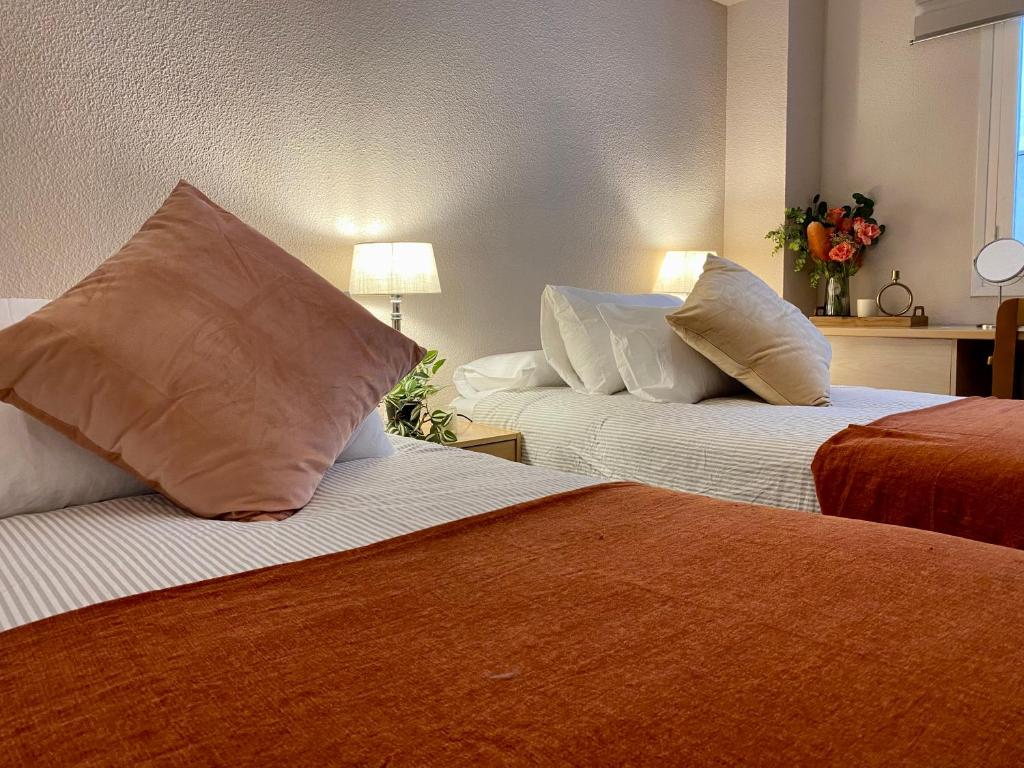 two beds with pillows in a hotel room at Habitación My Home Alicante in Alicante