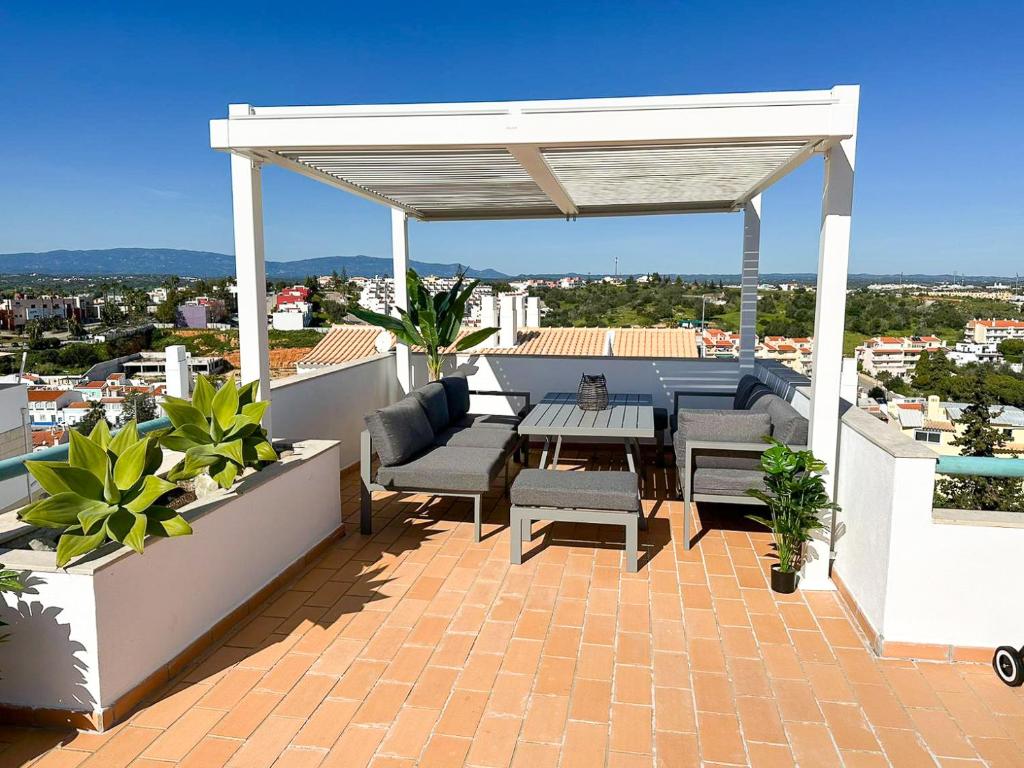 a patio with a table and chairs on a roof at Casa Rostam - Duplex avec Terrasses - Ferragudo in Ferragudo