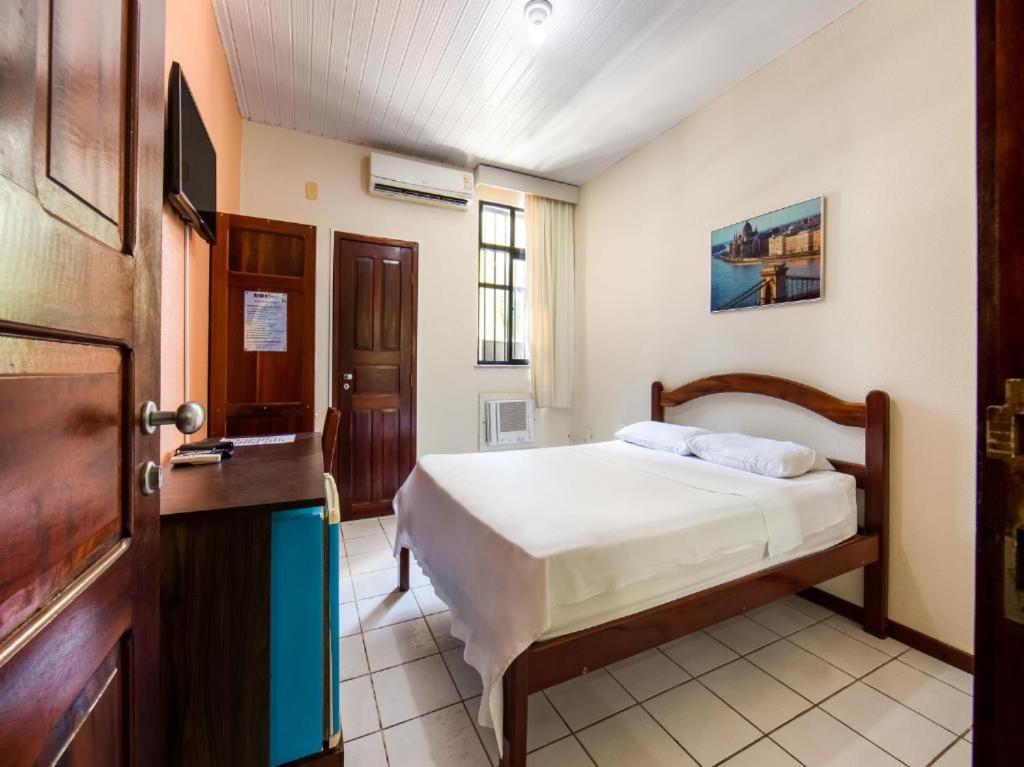 a bedroom with a bed and a wooden door at Hotel Netuno Beach in Fortaleza