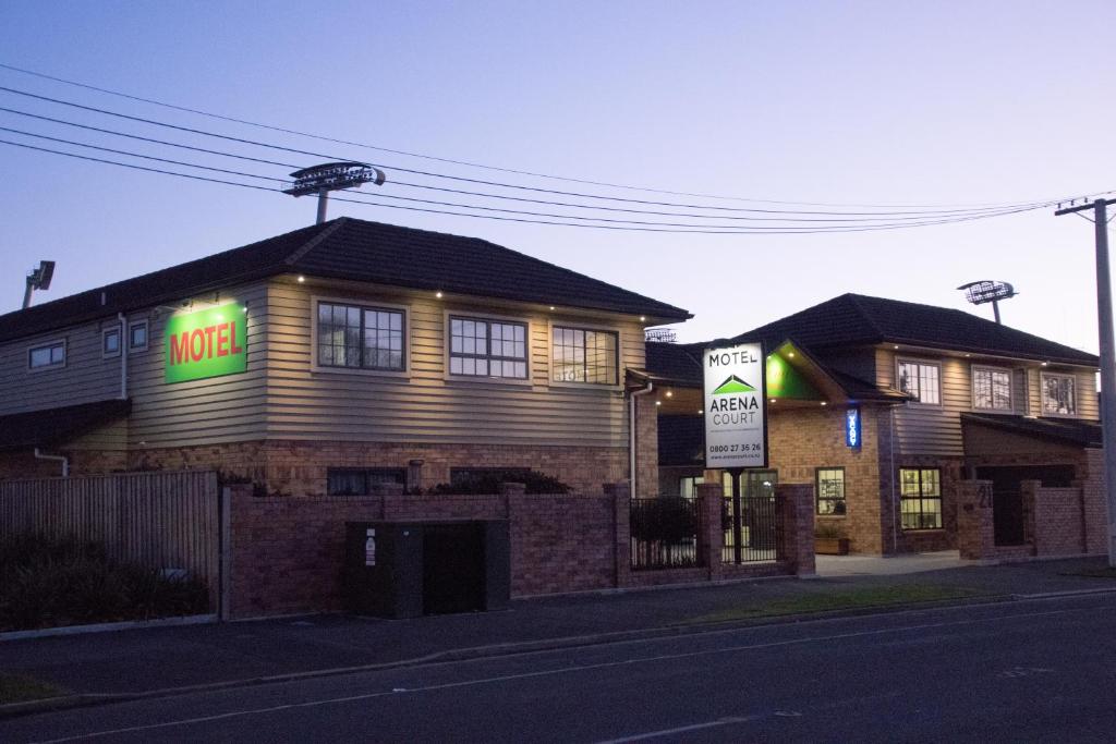 a house with a motel sign on the side of it at Arena Court Motel in Hamilton