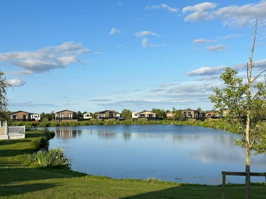 a large lake in a suburb with houses at Unwind@13 Badger Lakes, Haggerston, Northumberland in Beal