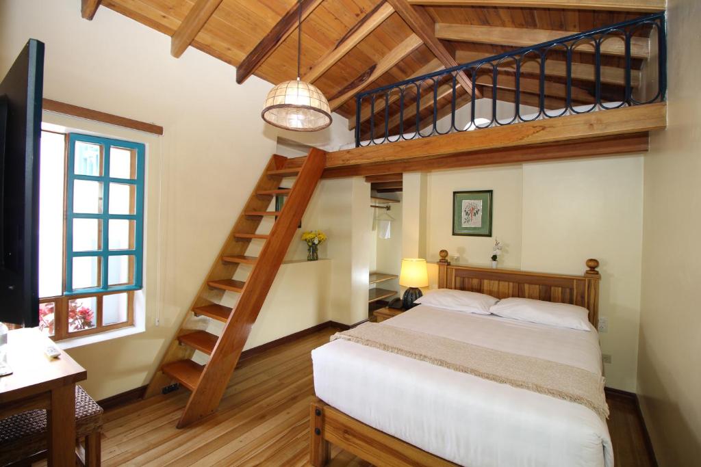 a bedroom with a loft bed and a staircase at Hotel Vieja Cuba in Quito