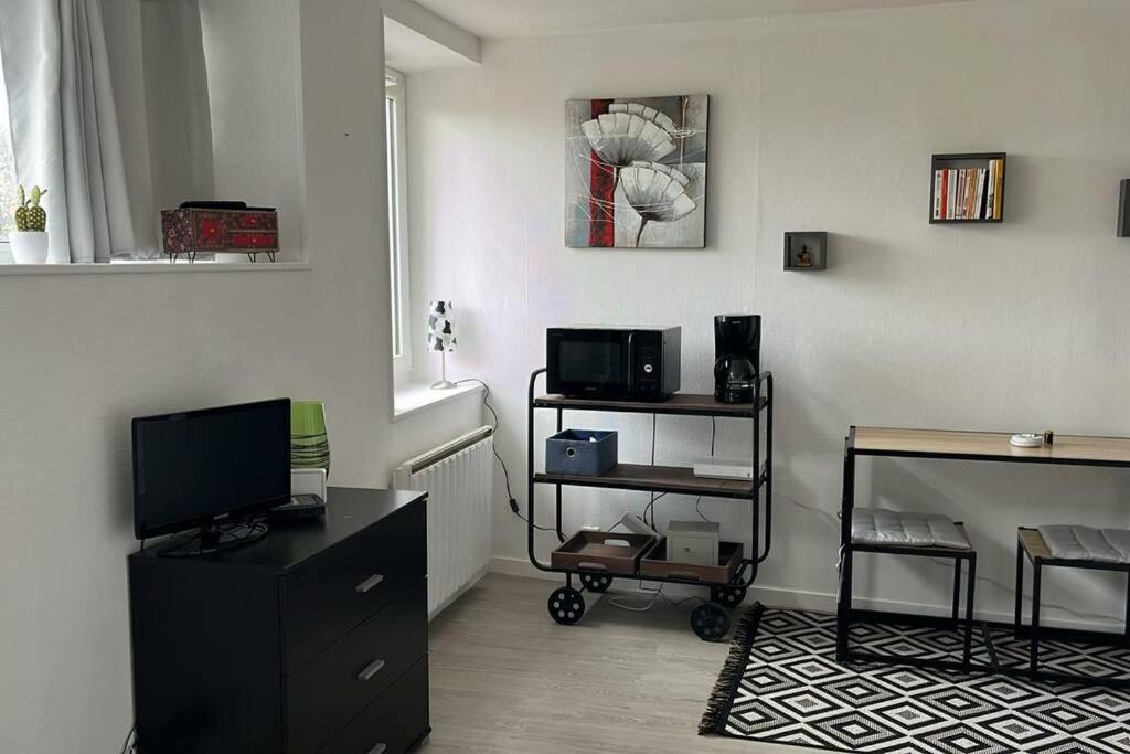 - un salon avec une télévision et un bureau dans l'établissement Studio proche du centre-ville, à La Rochelle