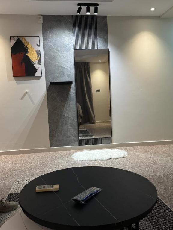 uma mesa com dois controlos remotos e um espelho em شقة بصالة مودرن وغرفة نوم em Buraydah