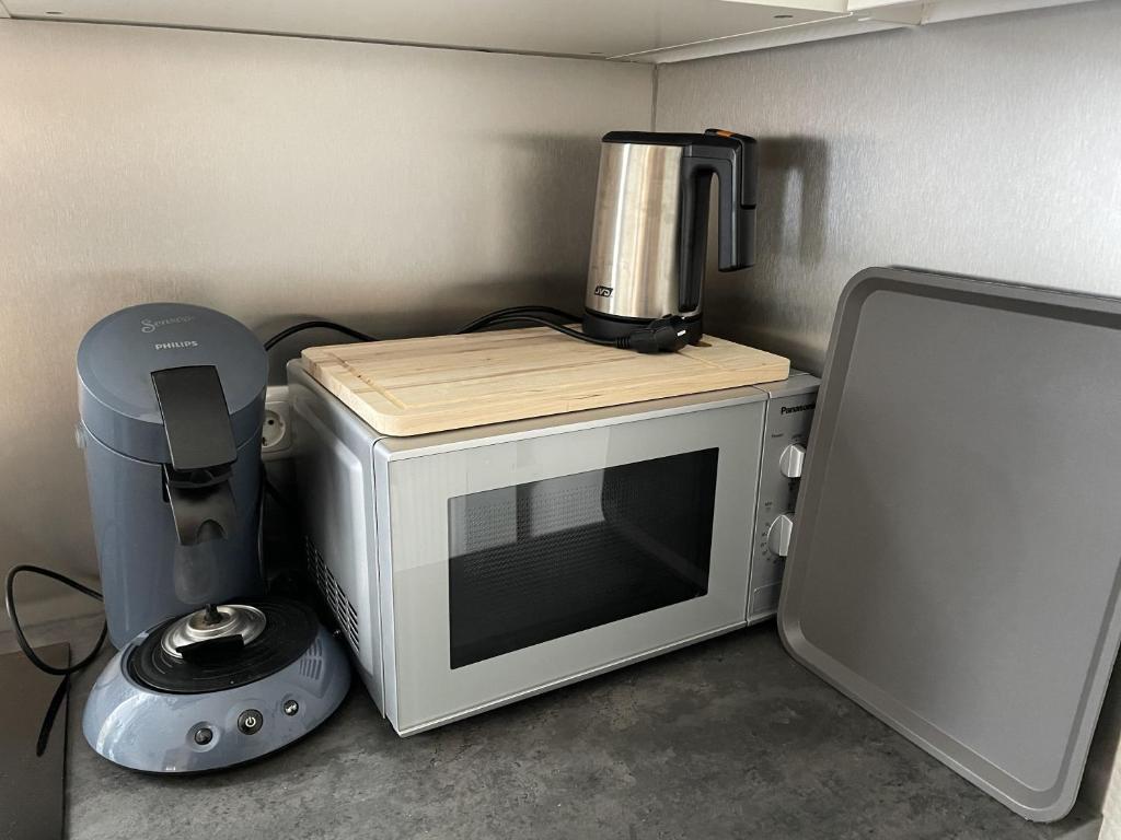 a microwave with a coffee maker on top of it at Appartement mitten in der Stadt in Mönchengladbach