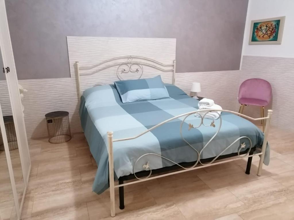 a bedroom with a bed and a purple chair at Sapore di mare house in Bari