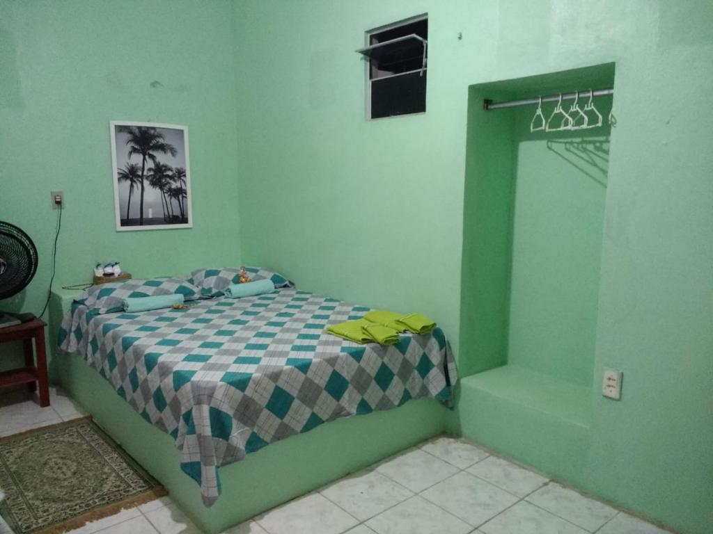 um quarto com uma cama numa sala verde em Casa Laranja em Cascavel