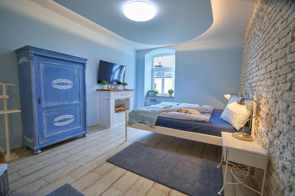 a bedroom with a bed and a blue cabinet at Apartmán U Pomněnky in Jeseník