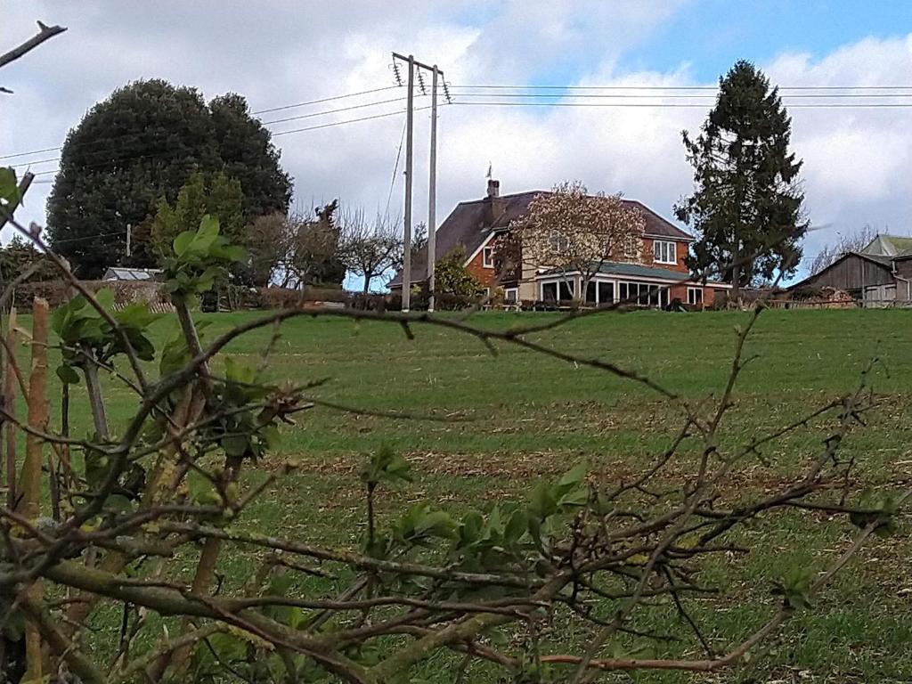 een huis in een groen veld met een huis bij Pool Farm in Redditch