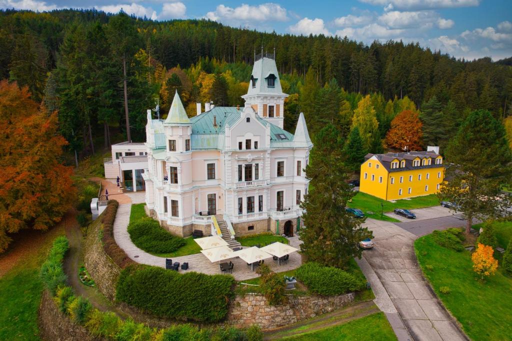 an aerial view of a large white house with a turret at Hotel Château Cihelny in Karlovy Vary