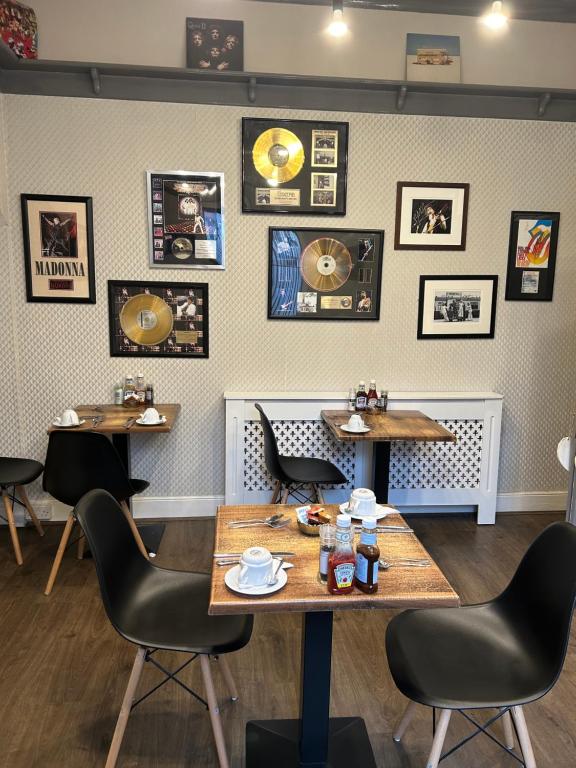 a restaurant with tables and chairs and pictures on the wall at The Woodszz guest house in Whitby